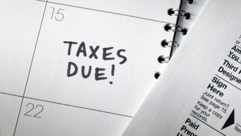 A paper calendar that has TAXES DUE! written in one of the squares.