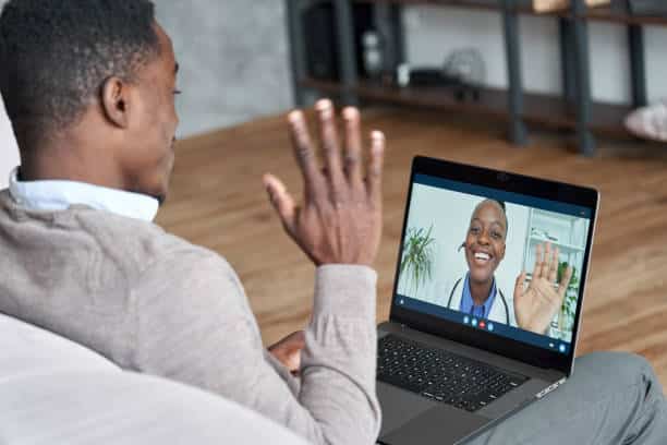The not-so-hidden mental health costs of being a founder 2 Male black patient talking on conference video call to female african doctor. Virtual therapist consulting young man during online appointment on laptop at home. Telemedicine chat, telehealth meeting