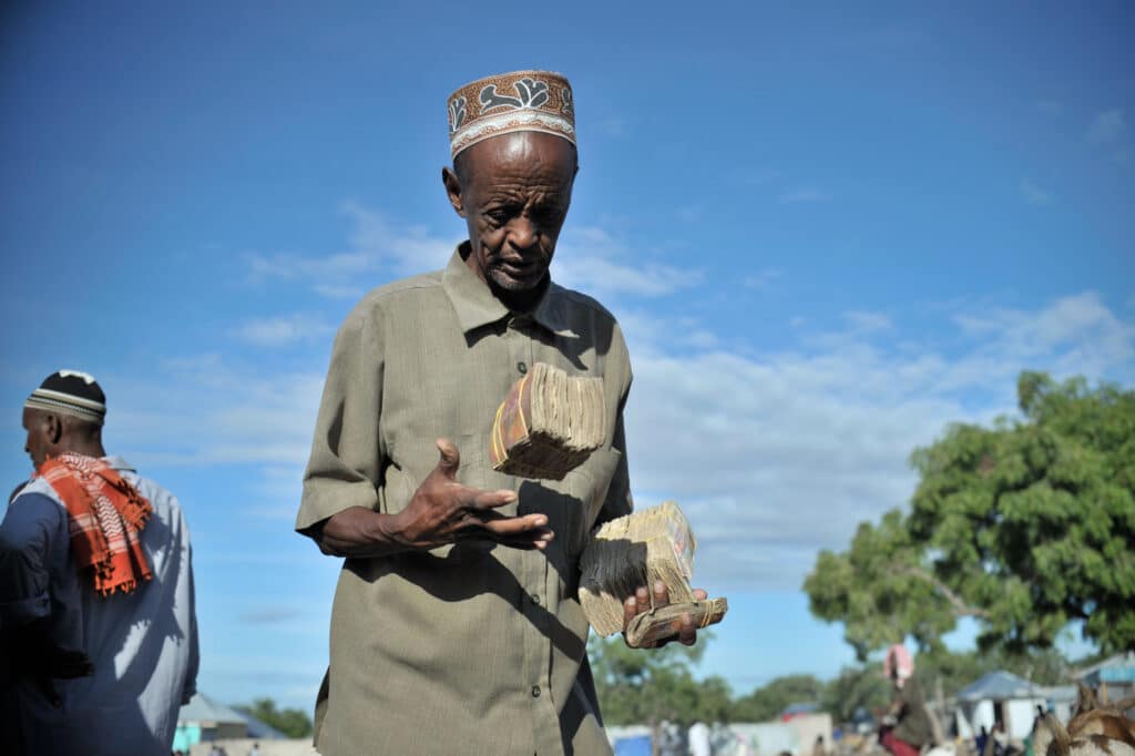 Uber to invest $100m in Moove 3 A Somali man carries the money he earned from selling goats at Bakara Animal Market in Mogadishu, Somalia, on April 13. Once notorious for being both the site of Black Hawk Down, in which 18 American soldiers were killed in 1993, and later as an al-Shabaab stronghold, Bakara market is now slowly losing its past notoriety and becoming better known for its thriving economy. In the district's animal market, thousands of goats are now brought each morning, where they are sold on to later be slaughtered for their meat. AU UN IST PHOTO / TOBIN JONES.
