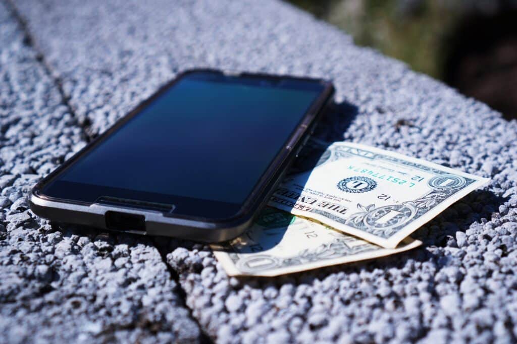 African ICT leaders urge tax cuts on digital gadgets 1 smartphone resting on dollar bill