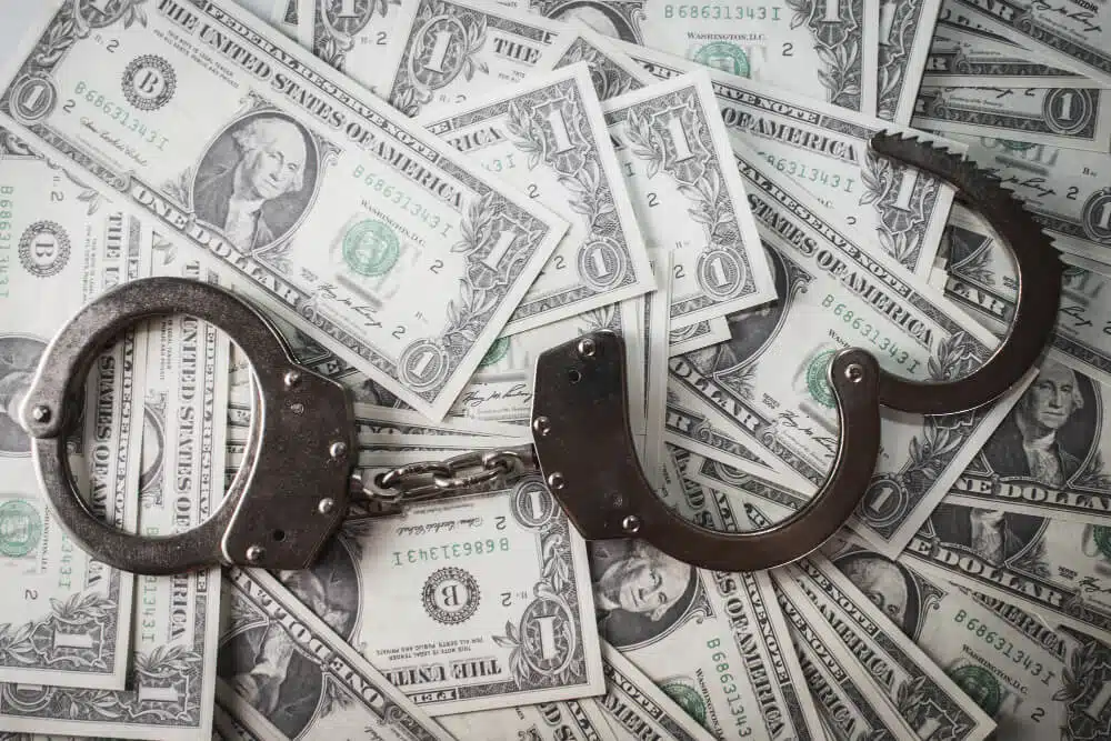 Several dollar notes and a handcuff, indication fraud