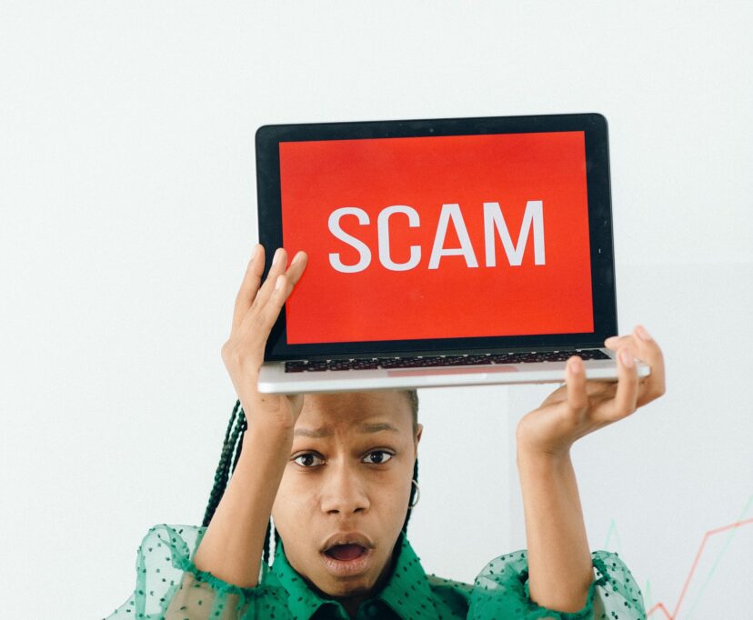 How to protect yourself from employment scams after getting laid off 1 Woman Holding a Laptop with a Scam Text