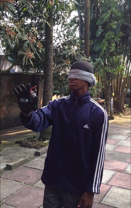 From gesture-controlled toy cars to smart gloves for the blind, this Nigerian teenager is changing how we think about hardware 1 A young man in blindfolds, holding out his hand that has an unusual glove worn on it.