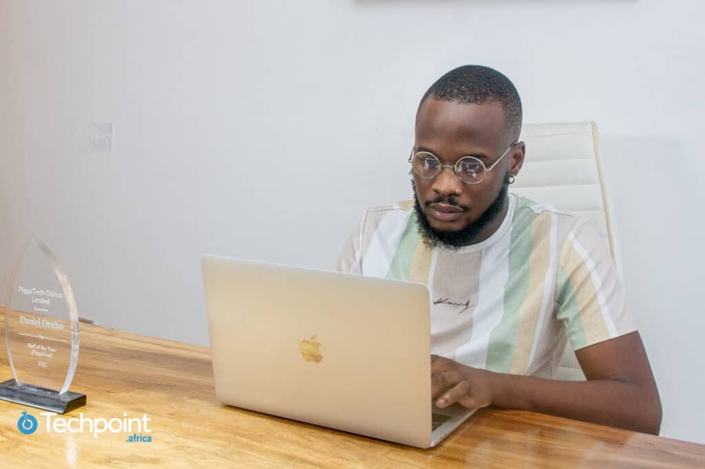 Meet Daniel Orubo, the creative storyteller behind Zikoko and Piggyvest's success stories 2 Daniel Orubo. Head of content and content strategy, Piggyvest sitting behind a desk and working on his Mac. On the desk is an award plaque as PiggyTech Global Limited Staff of the Year, 2022.