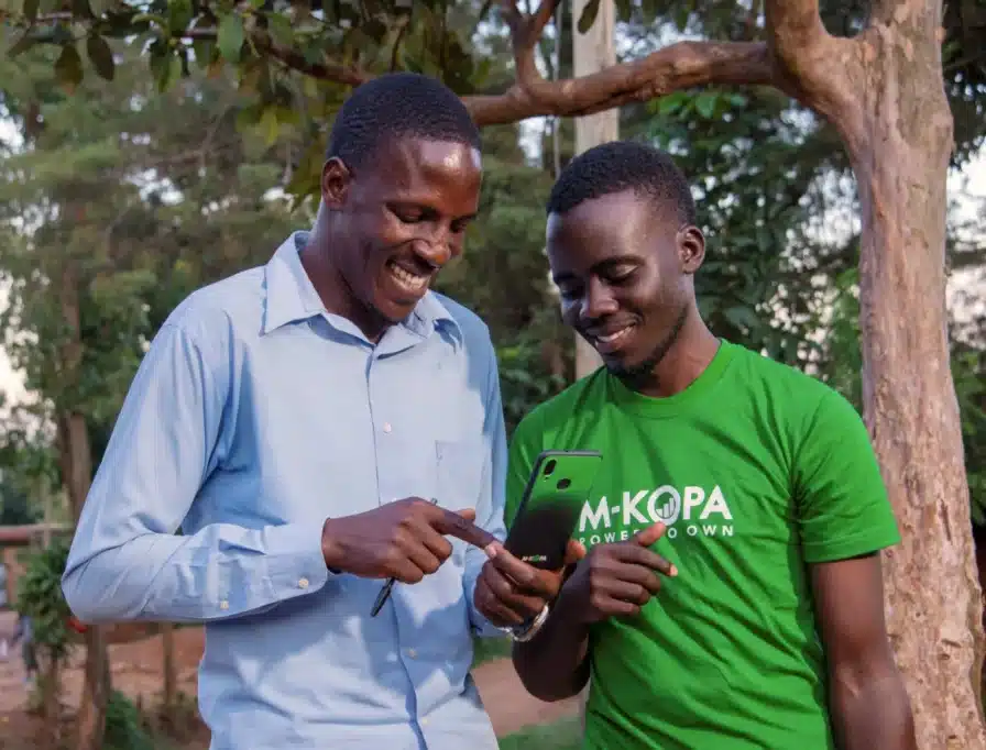 MTN GlobalConnect rebranding and M-KOPA's new funding 2 M-KOPA agent and customer looking at a smartphone