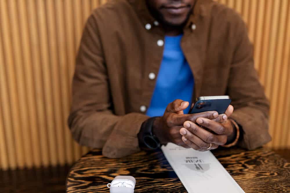 Ethiopia ends a 5-month social media ban 3 A picture of a man sitting in a restaurant holding is phone.