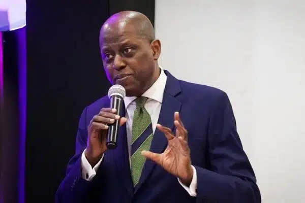 CBN governor, Yemi Cardoso holding a mic at what appears to be an event where he's addressing people