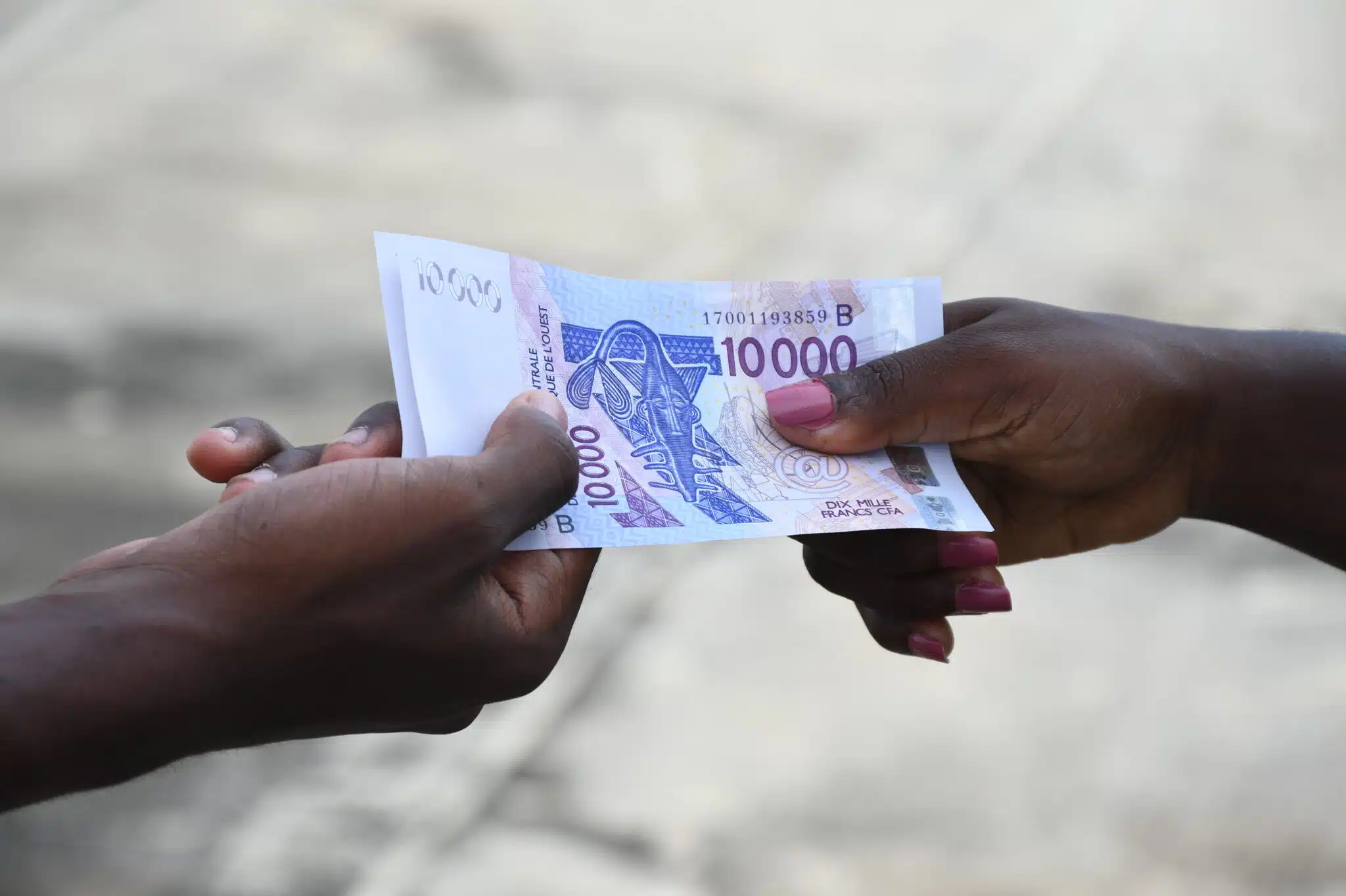 An image of two hands holding on to money
